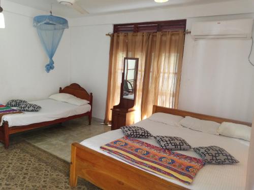 Un pat sau paturi într-o cameră la Thisara Pool Hotel Kataragama & Yala-Kabilththa Jeep Tour