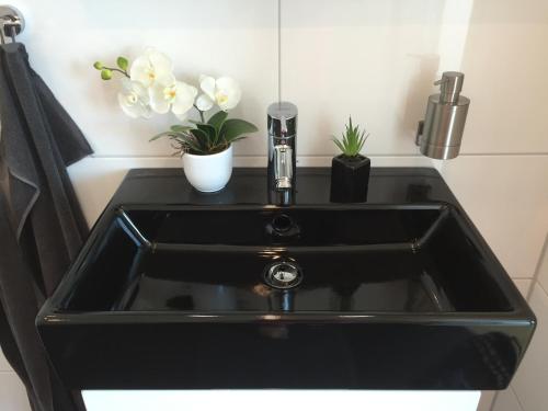 a black sink with two plants in a bathroom at Wohnung mit Weitblick in Dresden