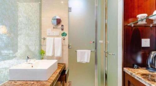 ein Badezimmer mit Waschbecken und Dusche in der Unterkunft Hotel Ramada Plaza Hangzhou Xiaoshan in Chang-shen-tien