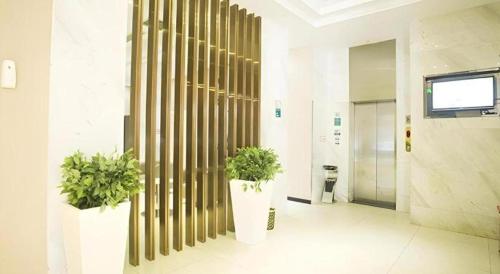 a hallway with two potted plants in a building at City Comfort Inn Ezhou Wenxing Avenue Central Hospital in Ezhou