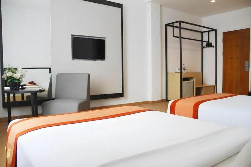 a hotel room with two beds and a television at Buana Lestari Hotel in Klandasan Kecil