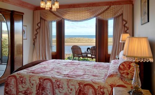 a bedroom with a bed with a view of the ocean at Apollo Bay Guest House in Apollo Bay