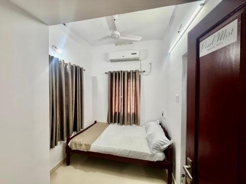 a small bedroom with a bed and a window at AETERNA Homestay in Fort Kochi