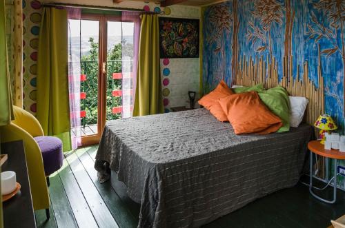 een slaapkamer met een bed met kleurrijke muren en een raam bij Casa sull'Albero in Lentella