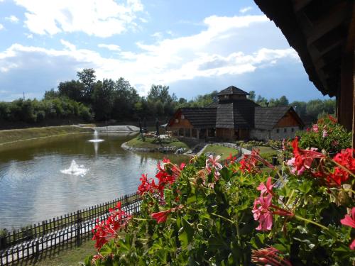a pond in front of a building with a house at Etno Selo Moravski Konaci in Velika Plana