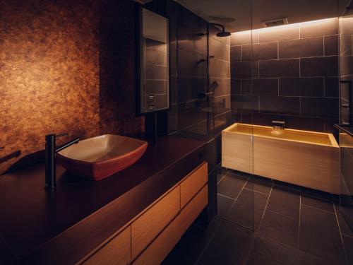 京都市にあるnol kyoto sanjoのバスルーム(バスタブ、シンク、バスタブタバーモット付)