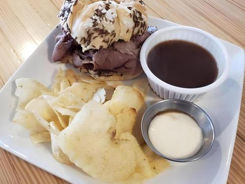 un piatto con un panino e patatine e una tazza di salsa di Keuka Lake Motel a Keuka