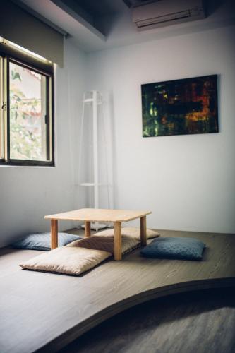a wooden table sitting on the floor in a room at So Art Guesthouse 旅人藝棧民宿 in Sanyi