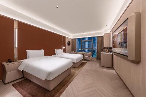 Ένα ή περισσότερα κρεβάτια σε δωμάτιο στο Orange Crystal Nanchang Honggutan MixC Hotel