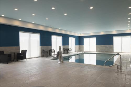 a pool with chairs and a table in a building at Hampton Inn & Suites Somerset in Somerset