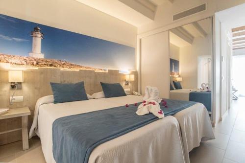 a bedroom with a bed with a stuffed animal on it at Hotel Voramar - Emar Hotels in Es Pujols