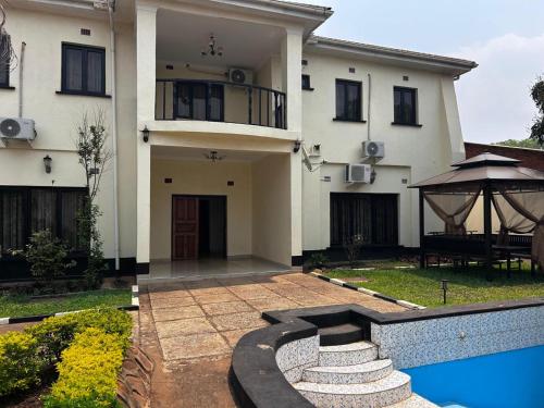 a house with a swimming pool in front of it at My Home Suites Area14 in Lilongwe