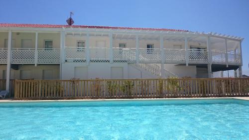 a building with a balcony and a swimming pool at Résidence Néméa Les Balcons des Pêcheurs in Mimizan-Plage