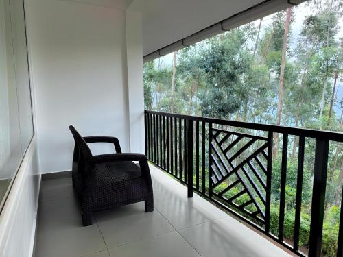 a balcony with a chair and a large window at Honeyrock Farm Resort by Skybz in Kanthalloor