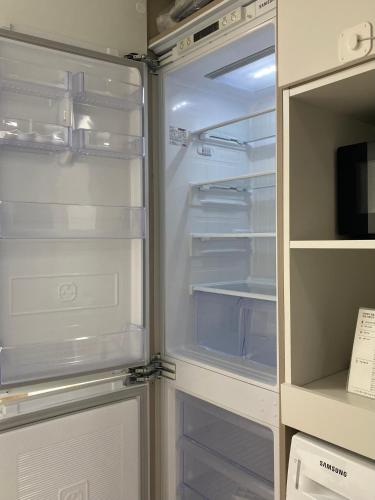 an empty refrigerator with its door open in a kitchen at 속초 오션뷰 써밋베이1205 in Sajin