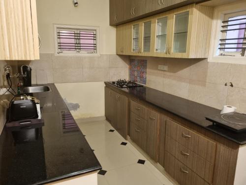 een grote keuken met houten kasten en een spoelbak bij Loto Villa in Bangalore