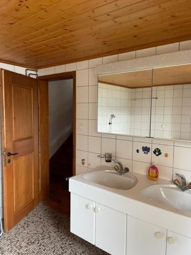 a bathroom with two sinks and a mirror at Ferienhaus am Sarnersee in Sachseln