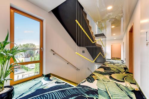 a hallway with yellow drawings on the floor and stairs at Baltic Sands in Hel