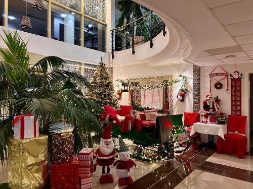 ein Wohnzimmer mit Weihnachtsdekoration und einem Weihnachtsbaum in der Unterkunft Calimbra Wellness Hotel Superior in Miskolctapolca