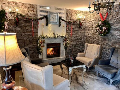 ein Wohnzimmer mit Kamin und Weihnachtsdekoration in der Unterkunft Calimbra Wellness Hotel Superior in Miskolctapolca