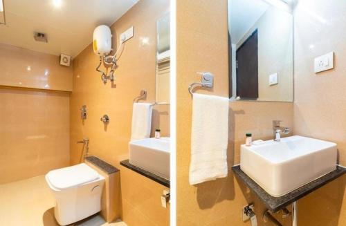 ムンバイにあるHotel AI inの洗面台、トイレ、鏡のあるバスルーム