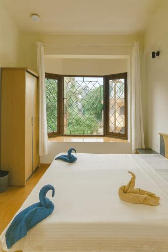 a bedroom with a large bed with blue towels on it at Navilehomestay in Candolim