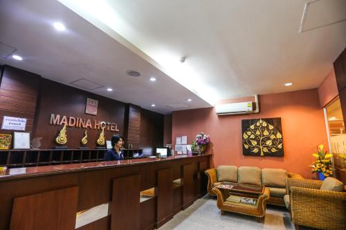 a man standing at a bar in a restaurant at Madina Rayong Hotel in Rayong