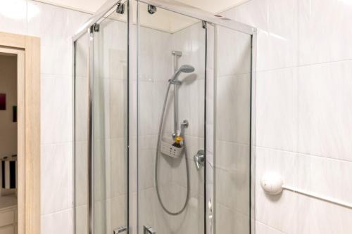 Adua Luxury Apartment في تارانتو: دش مع باب زجاجي في الحمام