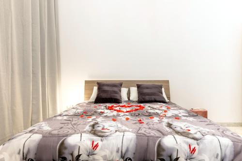 Adua Luxury Apartment في تارانتو: غرفة نوم بها سرير كبير وعليه زهور