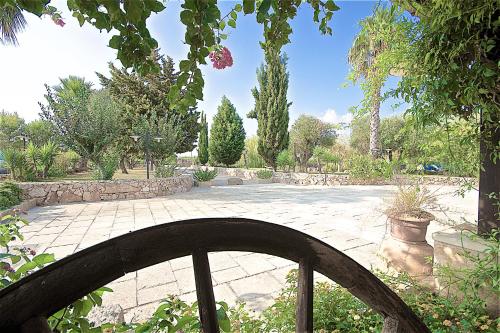 a stone walkway in a garden with trees at Hotel Masseria Le Pajare in Presicce