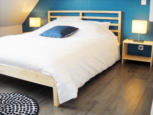 - une chambre avec un grand lit blanc et un mur bleu dans l'établissement Appartement Cosy Chic 3 Chambres, à Dieppe