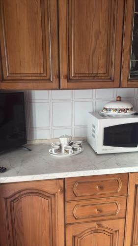 een aanrecht met een magnetron, kopjes en schotels bij 87 Apt in Bologna