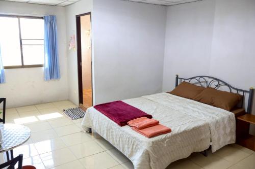a bedroom with a bed with two towels on it at DD House Apartment in Bangkok