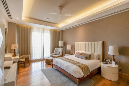 a large bedroom with a large bed and a chair at The Grand Luxxe Res Two Bedroom Loft- Riviera Maya in Nuevo Vallarta