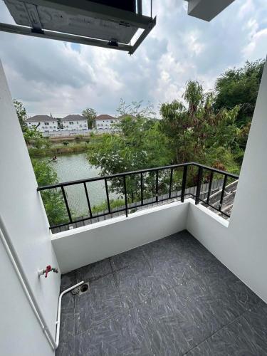 a balcony with a view of a river at Comfy Hotels Self Check in and Share Bathroom คอมฟี่ โฮเทล เช็คอินด้วยตนเอง และ ห้องน้ำรวม in Samutprakarn