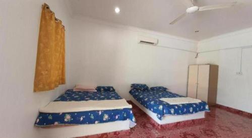 una camera da letto con due letti e una finestra di OYO 90302 Dimuara Chalet Tok Bali a Kampong Ayer Tawar