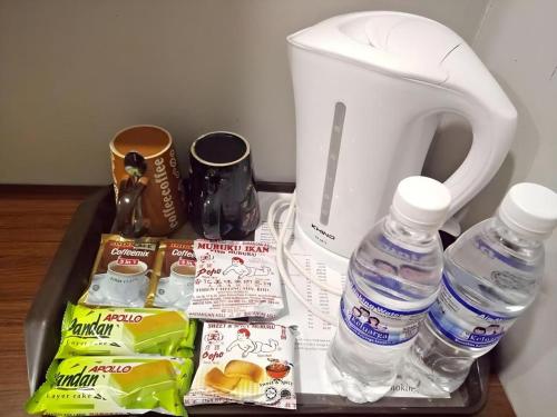 un vassoio con bottiglie d'acqua e un frullatore di Pendang Suite Hotel PLT a Pendang