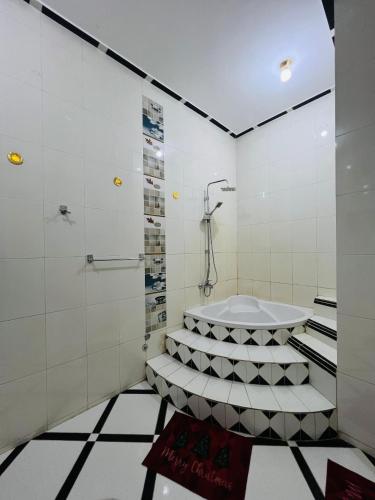 a bathroom with a tub and a shower at Luxor Adventure Guest House in Al Aqālitah