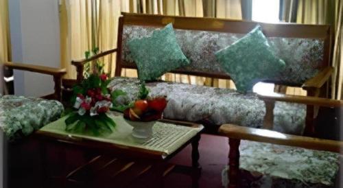 un soggiorno con un divano e un tavolo con fiori di Vasu Hotel Mahasarakham a Maha Sarakham