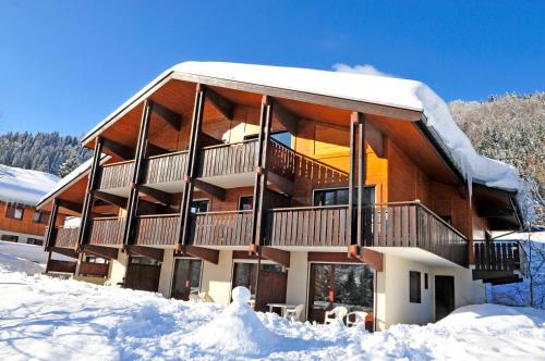 a large building with snow on the ground at Résidence Azureva La Clusaz les Aravis in La Clusaz
