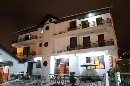 a building with tables and chairs in front of it at Hill View Hotel McCarthy Hills in Bortianor