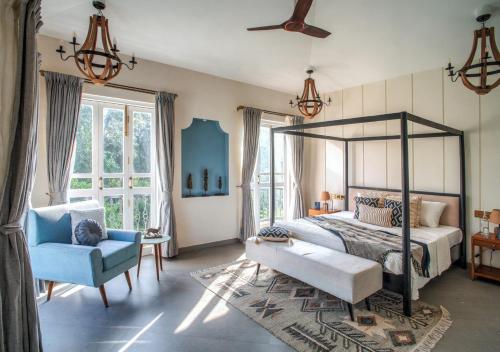 a bedroom with a canopy bed and a blue chair at LohonoStays Villa Beleza C in Oxel