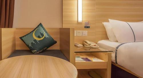 Zimmer mit einem Bett, einem Tisch und einem Telefon in der Unterkunft City Comfort Inn Nanning Jinhu Plaza Langxi Metro Station Exhibition in Nanning