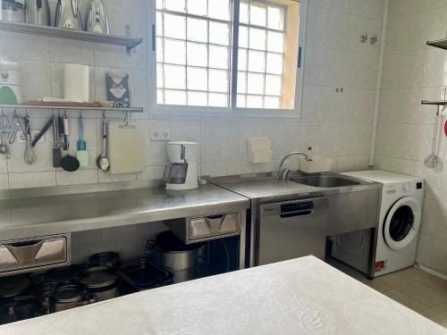 una cocina con fregadero y lavadora en Casona de Espirdo, en Espirdo