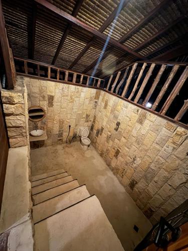 an empty room with a toilet in a brick wall at Living On Air in Pulau Sarang