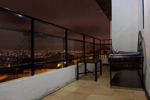 a balcony with a view of a city at night at Hill View Hotel McCarthy Hills in Bortianor
