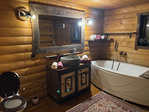 a bathroom with a tub and a toilet and a sink at Kosmajska Bajka in Rogača