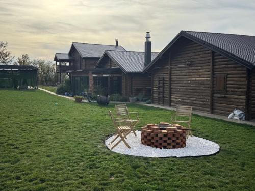 a house with two chairs and a fire pit in the yard at Kosmajska Bajka in Rogača
