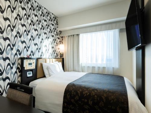 Giường trong phòng chung tại APA Hotel Takaoka Ekimae