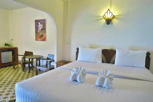 ナーンにあるNan Lanna Hotelのホテルルーム ベッド1台(白いタオル2枚付)